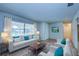 Bright living room with large window, white sofa with accent pillows and wood coffee table on patterned rug at 209 Meadow Hills Dr, Sanford, FL 32773