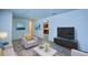 Cozy living room with neutral armchair, TV set on console and view into the kitchen at 209 Meadow Hills Dr, Sanford, FL 32773