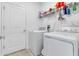 Bright laundry room with washer, dryer, and overhead shelving at 2910 Black Birch Dr, Ocoee, FL 34761