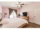 Bright bedroom features wooden frame bed, ceiling fan, and hardwood floors at 3022 Bransbury Ct, Kissimmee, FL 34747