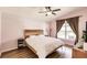 Cozy bedroom with a wooden frame bed, ceiling fan, and hardwood floors at 3022 Bransbury Ct, Kissimmee, FL 34747