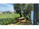 Wooden picnic table on patio with green umbrella and fenced yard at 3022 Bransbury Ct, Kissimmee, FL 34747
