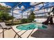 A screened-in pool area features a slide, lounge chairs, and a lush green surroundings at 3022 Bransbury Ct, Kissimmee, FL 34747