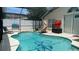 Freeform swimming pool with a slide and screened enclosure at 3022 Bransbury Ct, Kissimmee, FL 34747