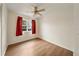 Bedroom with wood-look floors, window with red curtains, and ceiling fan at 3944 Janie Ct, Orlando, FL 32822