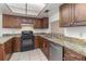 Kitchen with dark wood cabinets, granite counters, and appliances at 4392 S Lake Orlando Pkwy # 4, Orlando, FL 32808