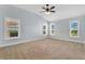 Bedroom featuring three windows and neutral carpeting at 5810 Penney Ln, The Villages, FL 32163