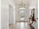 Bright entryway with decorative glass door, modern light fixture, and tiled flooring at 5810 Penney Ln, The Villages, FL 32163