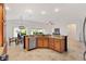 Open kitchen layout with island, granite countertops, stainless steel appliances, and dining space at 5810 Penney Ln, The Villages, FL 32163
