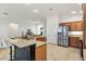 Open concept kitchen with a large island, stainless steel refrigerator, and granite countertops at 5810 Penney Ln, The Villages, FL 32163