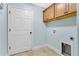 Well-lit laundry room featuring cabinetry, a utility sink, washer and dryer hookups, and tile flooring at 5810 Penney Ln, The Villages, FL 32163