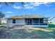 Home's back exterior showcasing screened porch and yard at 637 Twin Lake Ave, Deltona, FL 32738