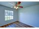 Bright bedroom with wood-look floors, ceiling fan, and large window at 637 Twin Lake Ave, Deltona, FL 32738