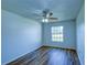 A bright room featuring hardwood floors, a ceiling fan, and a large window offering natural light at 637 Twin Lake Ave, Deltona, FL 32738
