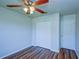 Spacious bedroom featuring wood-look floors, double-door closet, and ceiling fan at 637 Twin Lake Ave, Deltona, FL 32738