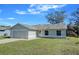 Newly renovated single-story home with gray siding, attached garage, and a well-maintained lawn at 637 Twin Lake Ave, Deltona, FL 32738