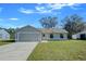 Newly renovated single-story home with gray siding, attached garage, and a well-maintained lawn at 637 Twin Lake Ave, Deltona, FL 32738