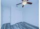 Bright bedroom with ceiling fan, double closet, and grey wood-look flooring at 824 Mentmore Cir, Deltona, FL 32738