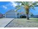 Gray house with palm tree and landscaped lawn at 824 Mentmore Cir, Deltona, FL 32738