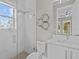 Modern bathroom with a glass shower, white tile, and floating shelves at 8348 Lindahl Aly, Orlando, FL 32827