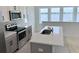 Modern kitchen with gray cabinets, stainless steel appliances, and lake views at 8348 Lindahl Aly, Orlando, FL 32827