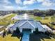 An aerial view of a community clubhouse, with a lake and fountain in the background at 1112 Hull Island Dr, Oakland, FL 34787