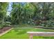 Peaceful backyard with lush tropical landscaping and a wooden bench at 1426 Nottingham St, Orlando, FL 32803