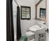 Classic bathroom with white tiling, black accents, pedestal sink, and shower curtain at 1426 Nottingham St, Orlando, FL 32803
