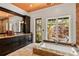 Bathroom featuring a large tub with granite surround, dark wood cabinetry, and natural lighting at 1426 Nottingham St, Orlando, FL 32803