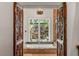 Luxurious bathroom featuring ornate wood doors and views of a stone wall garden at 1426 Nottingham St, Orlando, FL 32803