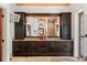 Bathroom featuring dual sinks, dark wood cabinets, and a view of the shower area through a mirror at 1426 Nottingham St, Orlando, FL 32803
