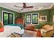 Serene bedroom with green walls, wooden furniture, and ample natural light at 1426 Nottingham St, Orlando, FL 32803