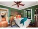 Charming bedroom with green walls, wooden accents, and a comfortable bed at 1426 Nottingham St, Orlando, FL 32803