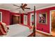 Spacious red bedroom with four-poster bed, hardwood floors, and an ensuite bathroom at 1426 Nottingham St, Orlando, FL 32803