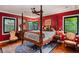 Luxurious bedroom with red walls, a large four-poster bed, and hardwood floors at 1426 Nottingham St, Orlando, FL 32803