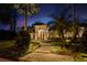 Elegant home exterior with lush landscaping, a stone walkway, and tropical palm trees under a dusk sky at 1426 Nottingham St, Orlando, FL 32803
