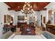Spacious living room with wooden ceiling beams, ornate chandelier, and travertine flooring at 1426 Nottingham St, Orlando, FL 32803