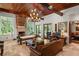 Expansive living room with fireplace, wood-beamed ceiling, and access to outdoor spaces through French doors at 1426 Nottingham St, Orlando, FL 32803