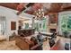 Open-concept living room with kitchen view, wood-beamed ceilings, tile floors, and abundant natural light at 1426 Nottingham St, Orlando, FL 32803
