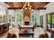 Elegant living room with wood-beamed ceiling, stone fireplace, tile flooring, and abundant natural light from large windows at 1426 Nottingham St, Orlando, FL 32803