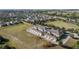 A drone shows exterior of townhomes featuring private garages and is surrounded by sprawling green spaces in neighborhood at 15322 Murcott Blossom Blvd, Winter Garden, FL 34787