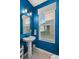 Modern powder room with pedestal sink and blue walls at 15322 Murcott Blossom Blvd, Winter Garden, FL 34787