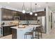 Modern kitchen with dark cabinetry, quartz countertops, and island at 15322 Murcott Blossom Blvd, Winter Garden, FL 34787