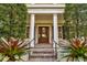 Elegant entryway with columns, a wood door, and lush landscaping at 4424 New Broad St, Orlando, FL 32814
