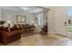 Living room with hardwood floors, brown couch, and a rocking chair at 663 Caterpillar Run, Winter Garden, FL 34787