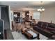 Open living area with hardwood floors, a brown leather couch, and a view of the kitchen and dining area at 11743 Stein St, Orlando, FL 32832