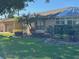 Tan house exterior with sunroom and a manicured lawn at 1641 Lake Marion Dr, Apopka, FL 32712