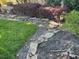 Stone pathway winds through a beautifully landscaped backyard with lush greenery at 1641 Lake Marion Dr, Apopka, FL 32712