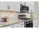 Modern kitchen with white cabinets, granite countertops, and stainless steel appliances at 2714 Stargrass Cir, Clermont, FL 34715
