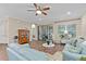 Bright living room with hardwood floors, comfy sofas, and sliding glass doors leading to a patio at 2714 Stargrass Cir, Clermont, FL 34715